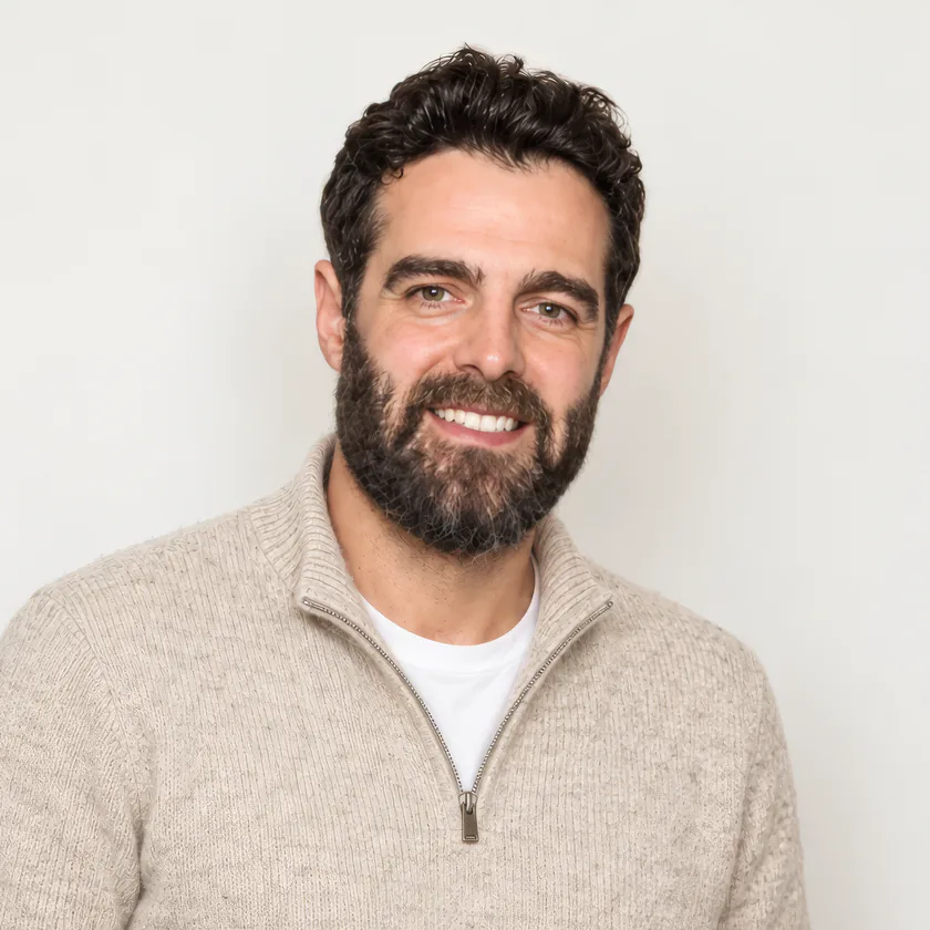 Sam, who builds and looks after every Website Studio site, smiling, in a cream quarter-zip jumper over a white t-shirt